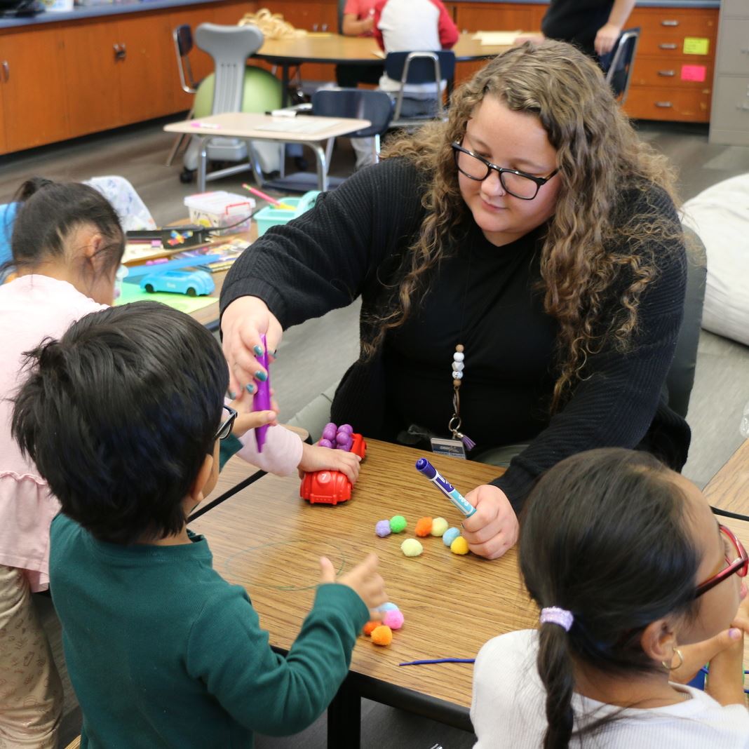  A student teacher works with manipulatives and students